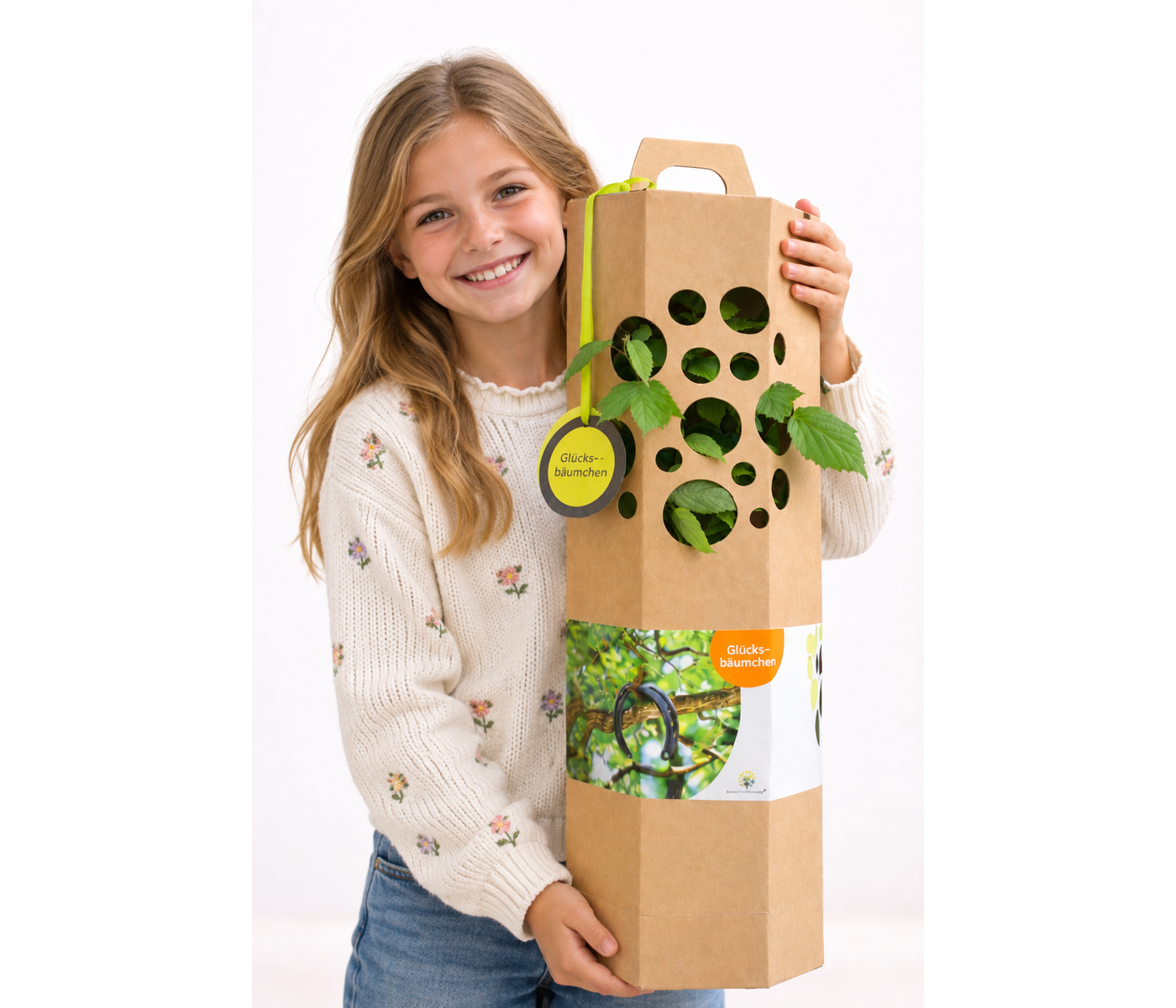 Schulkind hält den Einschulungsbaum in der Geschenkverpackung in den Händen