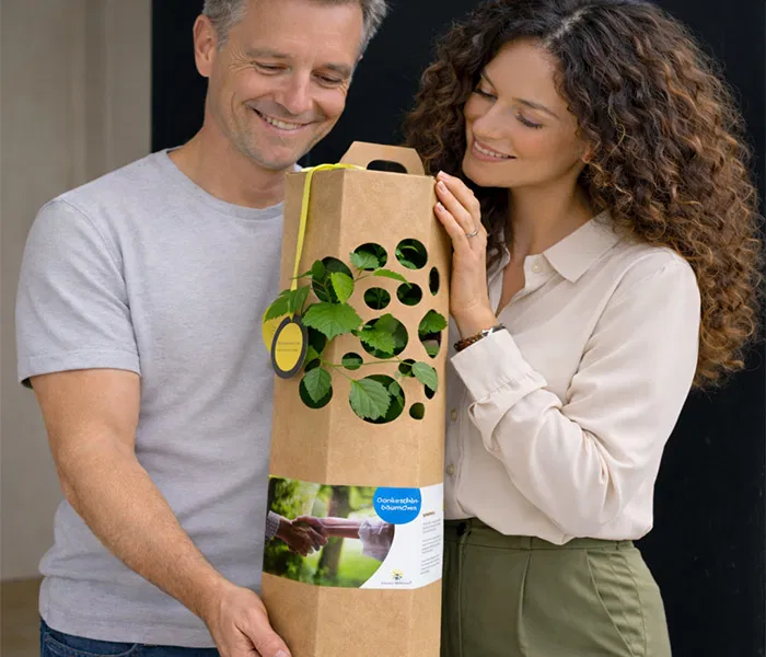 Man und Frau freuen sich ueber einen Dankeschon Baum