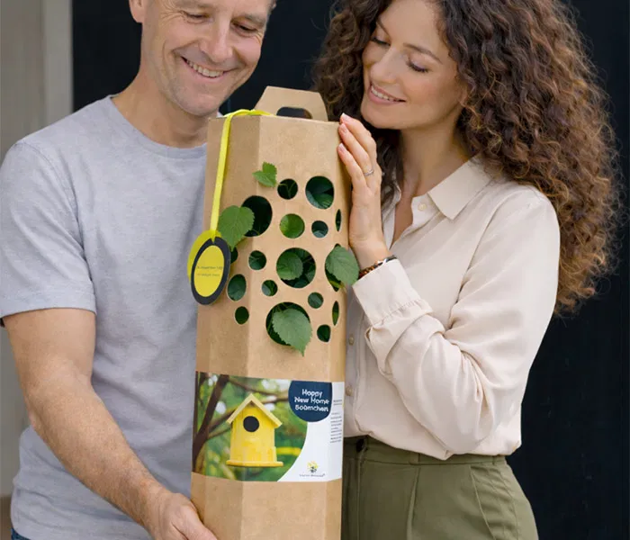 Man und Frau freuen sich ueber einen Happy New Home Wohnungbaum