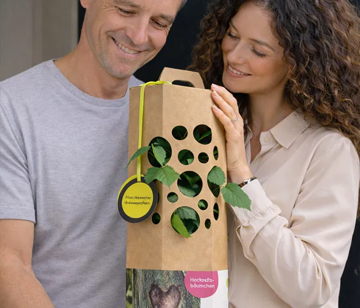 Man und Frau freuen sich ueber einen Hochzeitsbaum