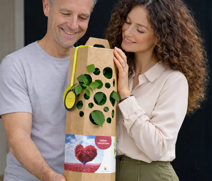 Man und Frau freuen sich ueber einen Liebesbaum