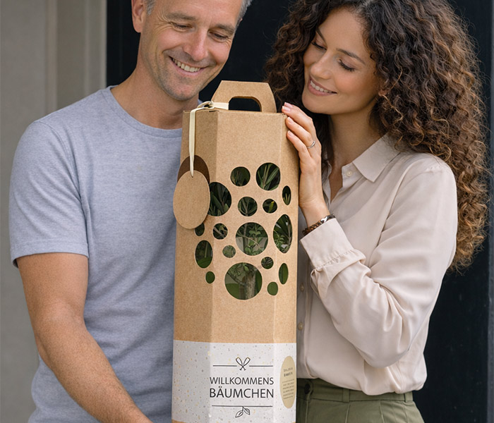 Mann und Frau freuen sich ueber ein Willkommensgeschenk