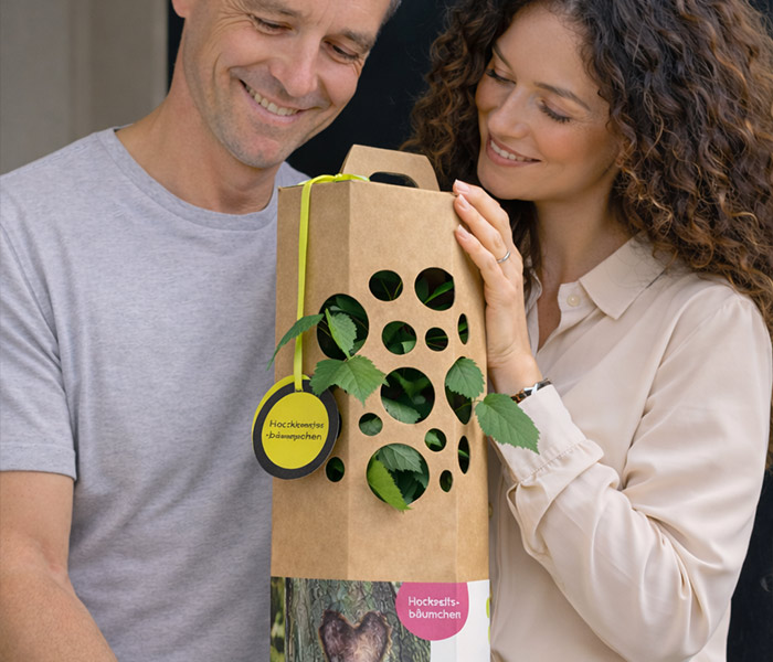 Man und Frau freuen sich über einen Hochzeitsbaum